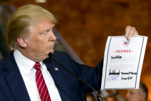 Republican presidential candidate Donald Trump looks at a signed pledge during a news conference in Trump Tower, Thursday, Sept. 3, 2015 in New York. Trump ruled out the prospect of a third-party White House bid and vowed to support the Republican Party's nominee, whoever it may be. (AP Photo/Richard Drew)