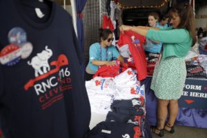 A woman checks out a tee shirt at a merchandise booth outside Quicken Loans Arena during first day of the Republican National Convention in Cleveland, Monday, July 18, 2016. (AP Photo/Matt Rourke)